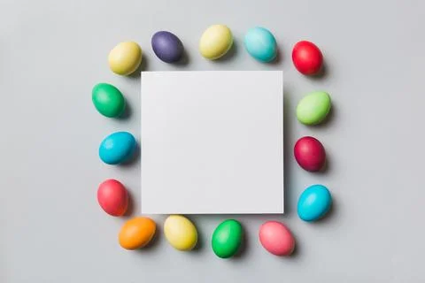 Round frame multicolored Easter eggs with white blank paper on a brown backgr Stock Photos
