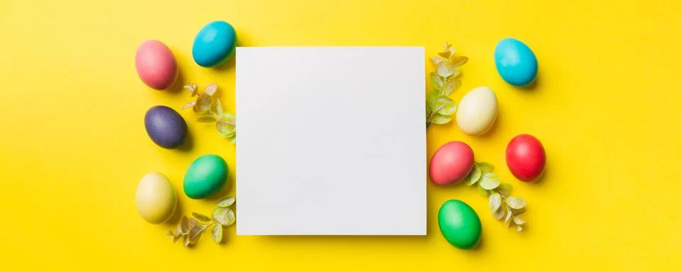 Round frame multicolored Easter eggs with white blank paper on a brown back.. Stock Photos
