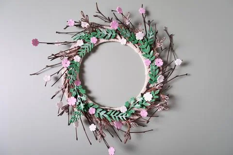 Round frame wreath pattern with pink flower buds, branches and leaves on gree Stock Photos