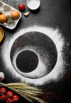 Round frames of flour with tomatoes, spikelets and eggs. Stock Photos