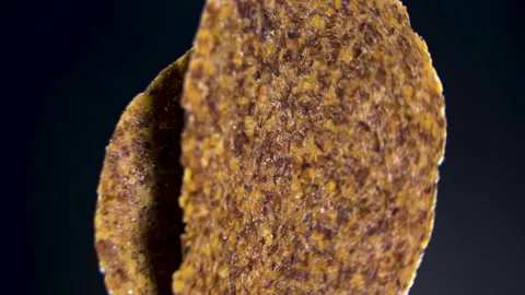 Round Fruit and Seed Crisp Rotating on Black Background, Close-Up Stock Footage 345611007