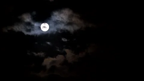 Round full moon in night sky as ominous dark clouds move past 動画素材 319849445