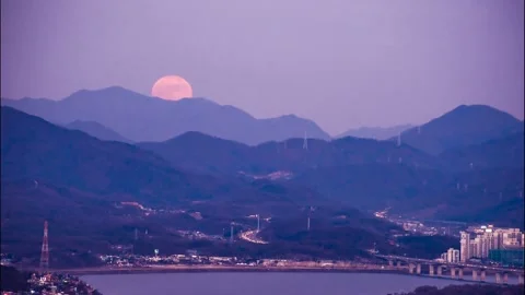 A round full moon rises. Time lapse Vidéo 145889189
