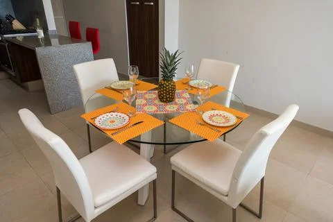 Round glass dining table set for four with colorful decor Stock Photos