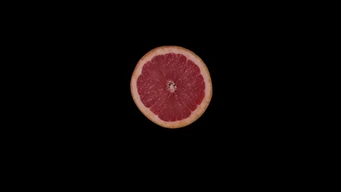 Round grapefruit slice rotates on a black background. Vídeos de archivo 125640596