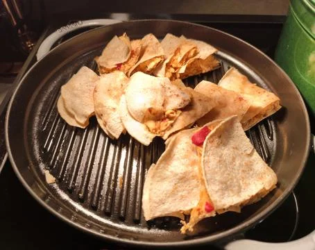 Round grill pan with folded chicken quesadillas Stockfoto's