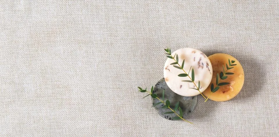The round handmade soaps with the twigs of eucalyptus on the cotton backgroun Stock Photos