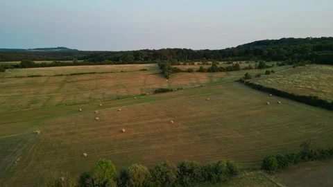 Round haystacks in a sunlit field Stock Footage 246373890