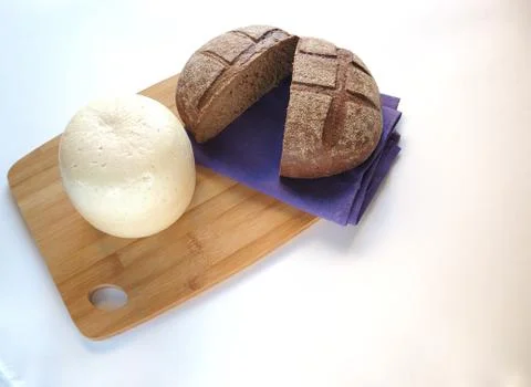 Round head of cheese with rustic fresh bread on a wooden tray. Stock Photos