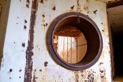 Round hole in the wall covered by rust. Stock Photos