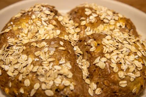 A round home baked bread roll covered in seeds Stock Photos
