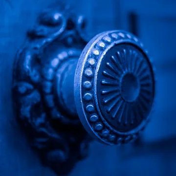 Round iron handle with pattern on an old door closeup. Blue tone. 스톡 사진