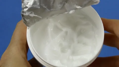 Round Jar of White Cream on Solid Blue Background Stock Footage 294889920