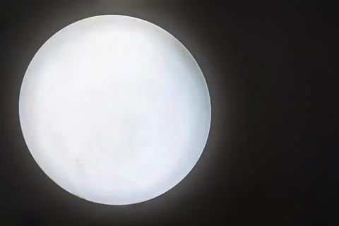 Round lamp in the darkness making impression of the moon or the sun Stock Photos