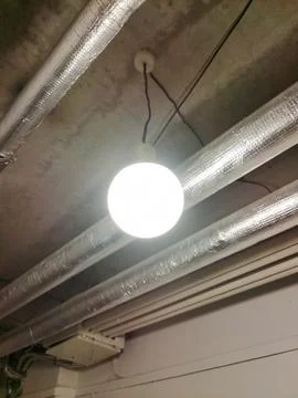 A round lantern hangs under the ceiling of a basement Stock Photos