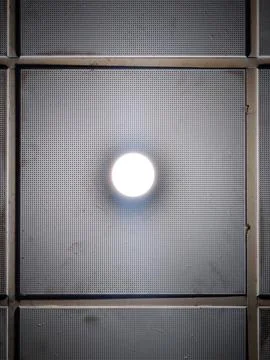 Round LED ceiling light on perforated metal acoustic panel Stock Photos