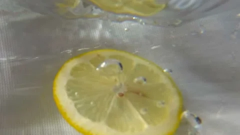 Round lemon slice plunging into water. Underwater high-speed slow motion Stock Footage 114226420