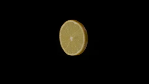 Round lemon slice rotates on a black background. Stock Footage 125640427