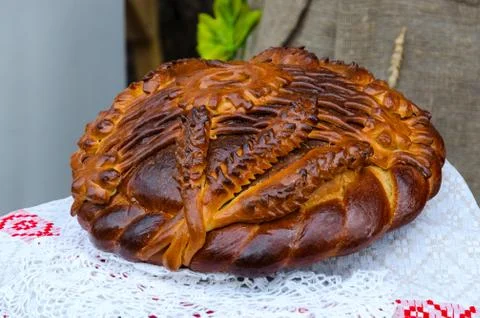 Round loaf with pattern on table covered with tablecloth Stock Photos
