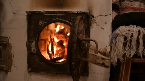 Round logs are burning in a stone oven. Hot coals radiate heat Stock Footage 145377300