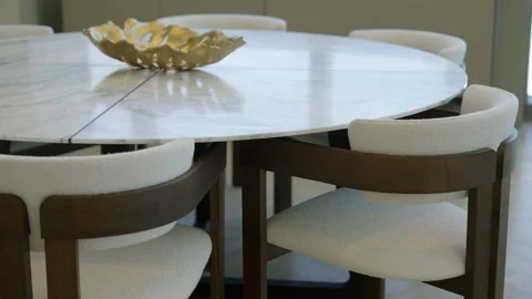 Round marble table with decorative golden bowl placed at center. Surrounding Stock Footage 295551239