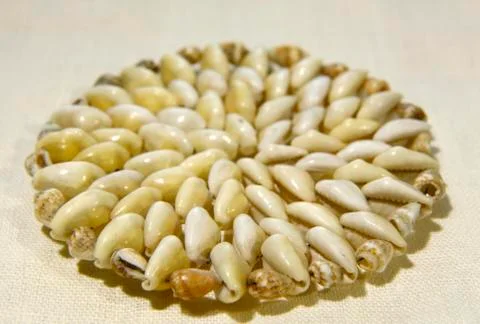 Round mat made of shells on the cloth side view selective focus close up Stock Photos