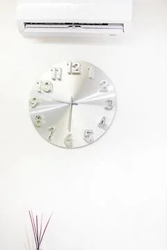 Round metal wall clock in a light interior Stock Photos