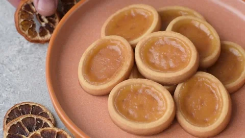 Round mini tartlets with citrus or peach jam and crumbly pastry. Mini citrus tar Stock Footage 332309839