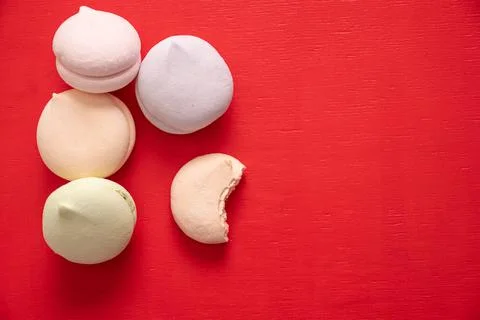 Round multi-colored marshmallows in a pile and one bitten half of a marshmall Stock Photos
