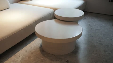 Round nesting coffee tables near modern sofa Stock Footage 311277989