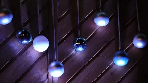 Round New Year's balls swing on wooden wall. 스톡 동영상 209823120