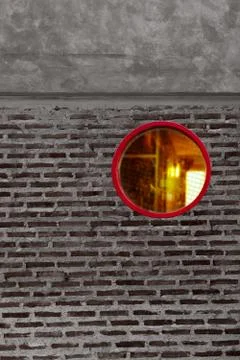 Round or circle red window on grey and black brick cement wall architecture d Stock Photos