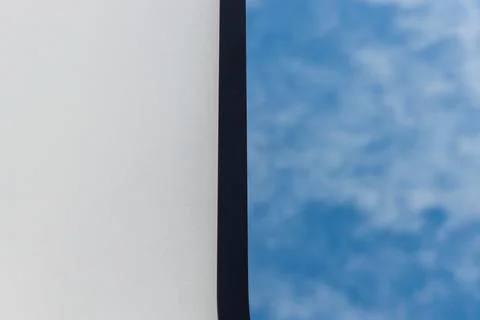 A round or oval mirror with a reflection of the blue sky and white clouds. Close Stock Photos