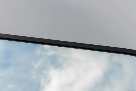 A round or oval mirror with a reflection of the blue sky and white clouds. Close Stock Photos