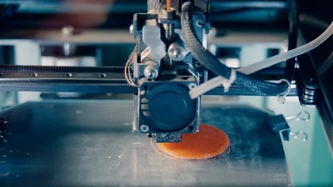 Round orange plate is getting printed in 3D. Three dimensional 3d printer 库存影片 124203259