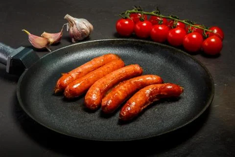 Round pan with five short fried hunting sausages Stock Photos