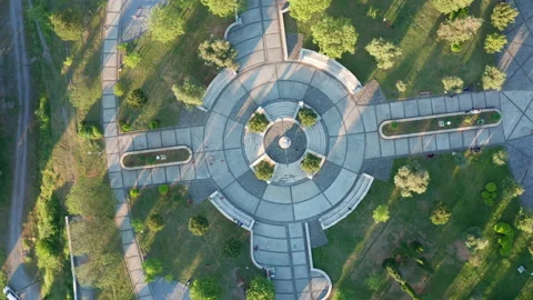 Round paved playground in a garden surrounded by trees and grass Stock Footage 153836835