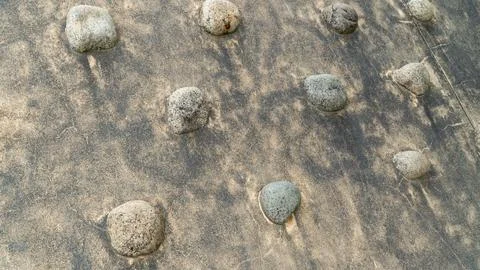 Round Pebbles Embedded in a Weathered Concrete Surface Stock Photos