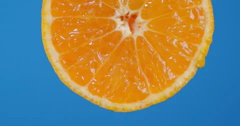 With a round piece of Mandarin falling drops of juice. Stock Footage 130521905