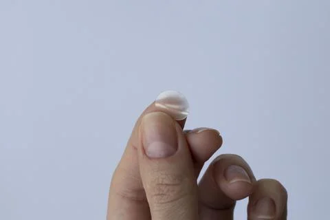 Round pimple patch in a woman's hand on a white background. Pimple Patches fo Stock Photos