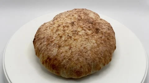 A round pita bread rotating on white background. Stock Footage 341009526