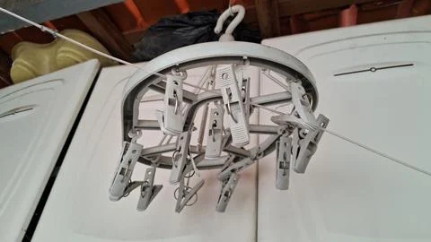 Round plastic clothes drying rack with many white laundry clips Stock Photos