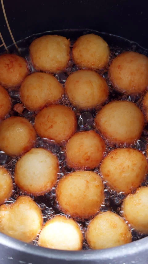 Round pot with lots of boiling oil and donuts frying in it.  Stock Footage 279486151