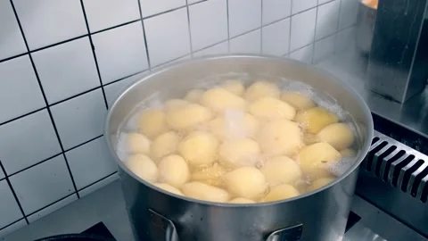 Round potatoes are cooked in a large saucepan in a restaurant Stock Footage 171592479