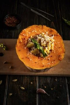 A round pumpkin shell holds a mix of grains and spices. Scattered herbs and.. Stock Photos