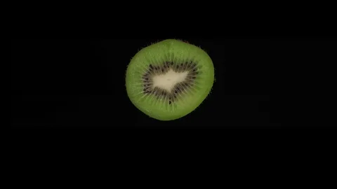Round ripe kiwi slice rotates on a black background. Stock Footage 125640717