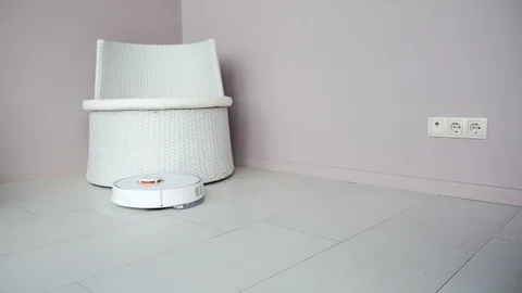 Round robot vacuum cleaner tidy up apartment. White vacuum cleaner automatically Stock Footage 117254804