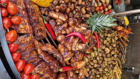 Round rotating grill with assorted meats and vegetables Stock Footage 275640509