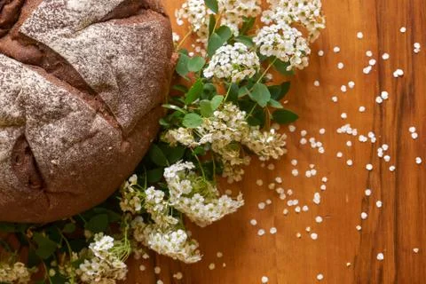Round rye bread with molasses on the old scratched mahogany table. Fresh home Stock Photos