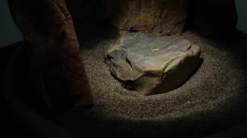 Round sand stage with centered stone under a focused beam of light Stock Footage 312517215